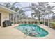 Screened-in pool area with a built-in spa, an outdoor grill, and lounge seating at 2737 Harvest Dr, Sarasota, FL 34240