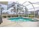 Screened-in pool with integrated spa and lush landscaping for a relaxing backyard oasis at 2737 Harvest Dr, Sarasota, FL 34240