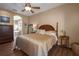 Cozy main bedroom with wooden floors, ceiling fan, complemented by a view of the ensuite bathroom at 3439 101St E Ave, Parrish, FL 34219