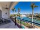 Enjoy the waterfront view from the balcony with chairs, ceiling fan, and black railings, perfect for relaxing outdoors at 367 W Royal Flamingo Dr, Sarasota, FL 34236