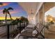 Sunset views from a covered balcony featuring lounge chairs, ceiling fan, and black railings, ideal for relaxation at 367 W Royal Flamingo Dr, Sarasota, FL 34236