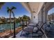 Waterfront views from a covered balcony with lounge chairs, ceiling fan, and black railings, ideal for relaxation at 367 W Royal Flamingo Dr, Sarasota, FL 34236