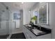 Modern bathroom with double vanity, black countertops, and glass shower at 367 W Royal Flamingo Dr, Sarasota, FL 34236