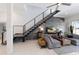Modern living room with an open staircase, water view, and stylish gray furniture at 367 W Royal Flamingo Dr, Sarasota, FL 34236