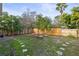 Fenced backyard with grassy area, picnic table, and mature trees at 4704 Town N Country Blvd, Tampa, FL 33615