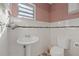 Small half bathroom with pedestal sink and toilet at 4704 Town N Country Blvd, Tampa, FL 33615