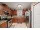 Kitchen with wood cabinets, granite counters, and appliances at 4704 Town N Country Blvd, Tampa, FL 33615