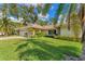 House exterior showcasing a well-maintained lawn and palm trees at 5607 Garden Lakes Majestic, Bradenton, FL 34203