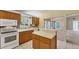 Kitchen with wood cabinets, white appliances, and an island at 5607 Garden Lakes Majestic, Bradenton, FL 34203