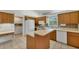 Kitchen with wood cabinets, island, and access to laundry area at 5607 Garden Lakes Majestic, Bradenton, FL 34203