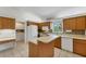 Kitchen with wood cabinets, island, and built-in appliances at 5607 Garden Lakes Majestic, Bradenton, FL 34203