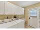 Laundry room with washer, dryer, cabinets, and exterior access at 5607 Garden Lakes Majestic, Bradenton, FL 34203