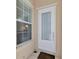 White front door with sidelights and a sheer curtain at 5835 Benevento Dr, Sarasota, FL 34238