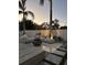 Backyard oasis with modern seating, a fire pit, pavers, and lush landscaping under palm trees at 5906 Larchwood Ave, Sarasota, FL 34231