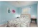 Bedroom with light blue walls and floral bedding at 6308 Lilac Pl, Sarasota, FL 34231
