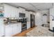 Modern kitchen with white cabinets, granite counters, and stainless steel appliances at 6308 Lilac Pl, Sarasota, FL 34231