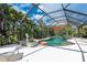 Inviting pool and spa with screened enclosure and lush tropical landscaping at 6308 Lilac Pl, Sarasota, FL 34231