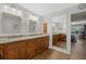Bright bathroom with a long granite countertop, & sinks, and a mirror that shows the view to a bedroom at 7207 Oak Moss Dr # 63, Sarasota, FL 34241