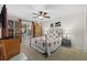 Bright bedroom featuring carpet floors, a ceiling fan, large window with natural light, and a unique bed frame at 7207 Oak Moss Dr # 63, Sarasota, FL 34241