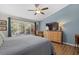 Primary bedroom featuring a blue accent wall, wooden furniture, and an oversized window with beautiful backyard views at 7207 Oak Moss Dr # 63, Sarasota, FL 34241