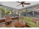 Inviting sunroom with large windows, wood-look flooring, comfortable seating, and views of the surrounding greenery at 7207 Oak Moss Dr # 63, Sarasota, FL 34241