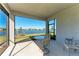 Screened-in lanai with seating, overlooking a serene lake and lush green lawn at 9244 Ballaster Pointe Loop, Parrish, FL 34219