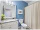 Bathroom features a shower with curtain, granite vanity top, and light blue walls at 10379 Medjool Dr, Venice, FL 34293