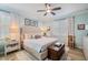 Comfortable bedroom featuring a tufted headboard, neutral decor, and a ceiling fan at 10379 Medjool Dr, Venice, FL 34293
