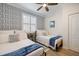Stylish bedroom with two twin beds, patterned wallpaper, and comfortable bedding at 10379 Medjool Dr, Venice, FL 34293