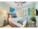 Light and airy bedroom with a queen bed, ceiling fan, and modern decor at 10379 Medjool Dr, Venice, FL 34293