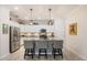 Modern kitchen with white cabinets, granite countertops, a stainless steel refrigerator, and pendant lighting over an island at 10379 Medjool Dr, Venice, FL 34293