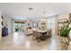 Open-concept living room with tile flooring, neutral decor, dining table, and access to an outdoor patio at 10379 Medjool Dr, Venice, FL 34293