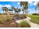 Playground nestled amongst palm trees with walkway and view of the lake at 10379 Medjool Dr, Venice, FL 34293