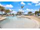 Resort-style pool with ample seating surrounded by palm trees under a sunny sky at 10379 Medjool Dr, Venice, FL 34293
