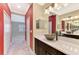 Bathroom with dual sinks, marble countertop, unique vessel sinks, and red accent walls at 21620 Avon Park Ct, Venice, FL 34293