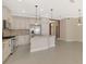 Bright kitchen with stainless steel appliances, white cabinets, and an island with seating at 21620 Avon Park Ct, Venice, FL 34293