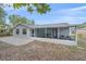 An enclosed back porch with neutral color and a doorway into the home with an open brick patio area at 2551 W Burr Oak Ct, Sarasota, FL 34232