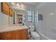 Full bathroom with wood cabinets and tiled shower and tub at 2551 W Burr Oak Ct, Sarasota, FL 34232
