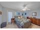 Cozy bedroom with a floral bedspread, wood floors, and a ceiling fan at 2551 W Burr Oak Ct, Sarasota, FL 34232