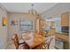 Dining area adjacent to kitchen with wooden table, chairs, and stylish light fixture at 2551 W Burr Oak Ct, Sarasota, FL 34232