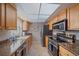 Bright kitchen with stainless steel appliances, granite countertops, and tile floors at 2551 W Burr Oak Ct, Sarasota, FL 34232