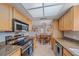 Spacious kitchen featuring stainless steel appliances and granite countertops, adjacent to dining area at 2551 W Burr Oak Ct, Sarasota, FL 34232