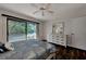 Light bedroom with dark wood floors, a large sliding glass door, and a white dresser with mirror at 1626 Stickney Point Rd # 26-102, Sarasota, FL 34231