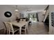 Bright living area with tile floors, dining table, stairs, and sliding glass door to outdoor patio at 1626 Stickney Point Rd # 26-102, Sarasota, FL 34231