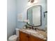 Charming powder room features a granite vanity and decorative mirror at 1810 Lincoln Dr, Sarasota, FL 34236