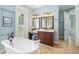 Elegant bathroom featuring a soaking tub, light walls, and a vanity area with a stool at 1810 Lincoln Dr, Sarasota, FL 34236