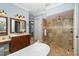 Bright bathroom features a soaking tub, vanity and glass shower with tiled walls and floor at 1810 Lincoln Dr, Sarasota, FL 34236