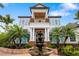 Elegant home featuring a covered balcony, vibrant landscaping, and a beautiful tiered fountain at 1810 Lincoln Dr, Sarasota, FL 34236