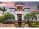 Elegant home featuring a covered balcony, vibrant landscaping, and a beautiful tiered fountain at 1810 Lincoln Dr, Sarasota, FL 34236
