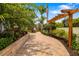Manicured walkway with lush landscaping and a pergola frames the entrance at 1810 Lincoln Dr, Sarasota, FL 34236